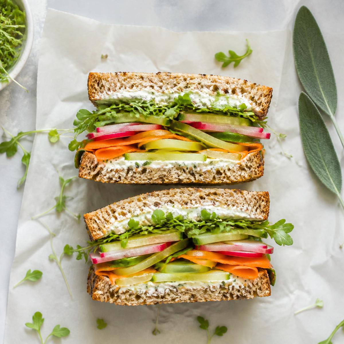 Sandwich aux crudités coupé en deux sur papier sulfurisé